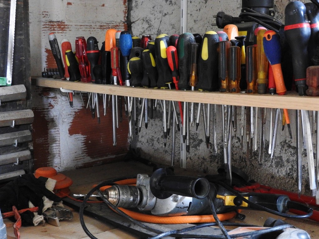 Schroevendraaiers en ander gereedschap op een plank in een werkplaats